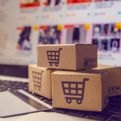 Small order boxes on top of a laptop showing an online shop